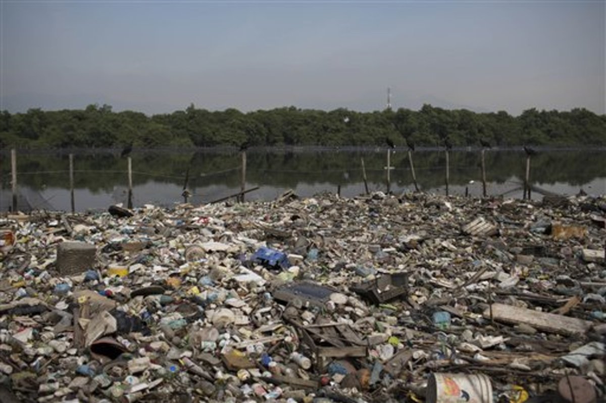 In this May 15, 2014 photo, trash floats on a polluted water channel that flows into the Guanabara Bay in Rio de Janeiro, Brazil. In its 2009 Olympic bid, officials promised that the city's waterways would be cleaned up but Brazil will not make good on it