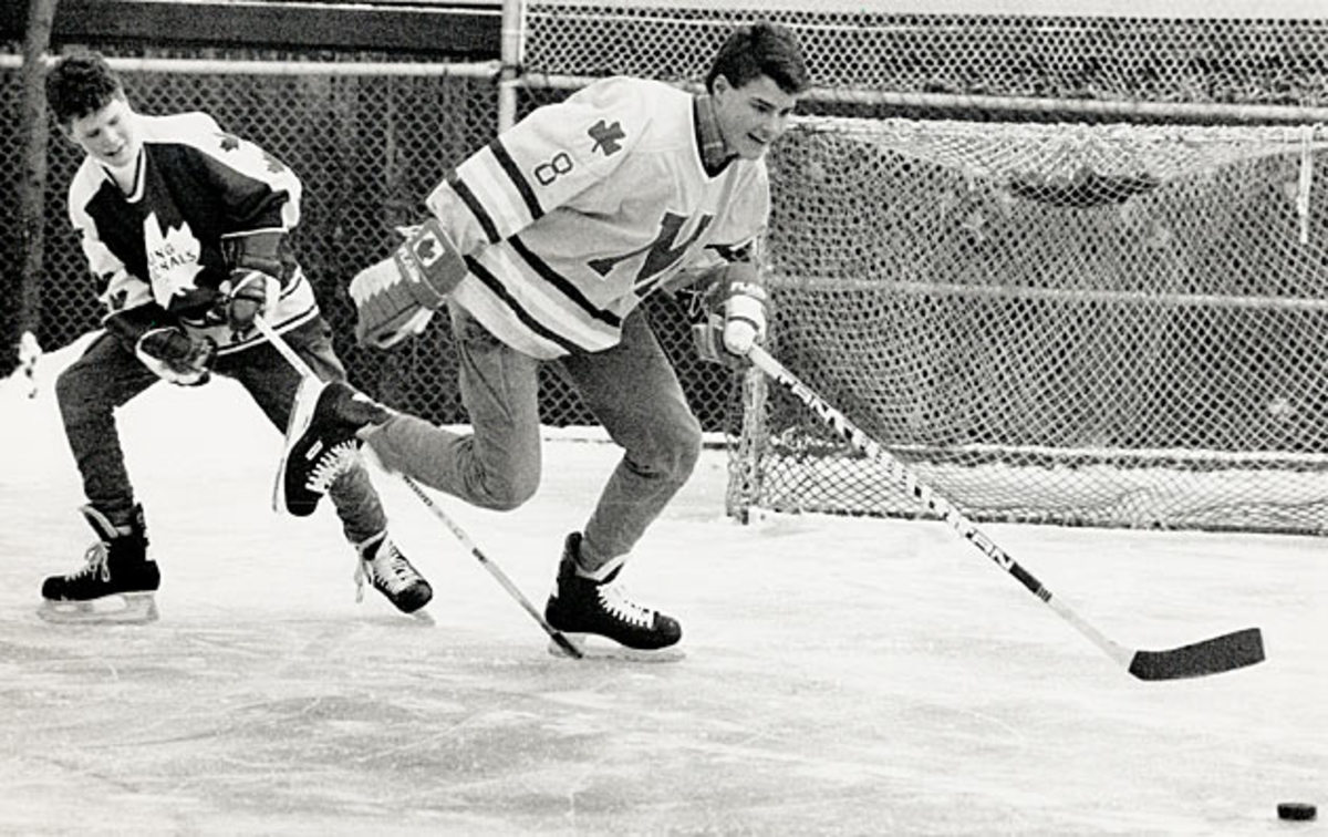 Eric and brother Brett play shinny in their backyard.