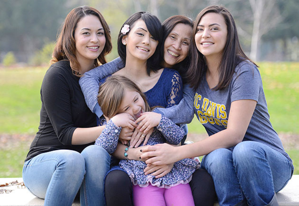 Brittany Bryan surrounded by her family, holding her four-year-old daughter Lyla.