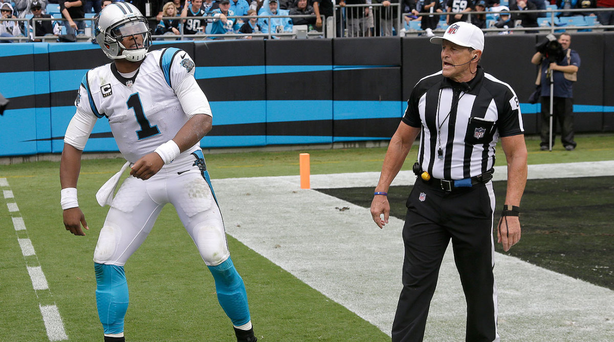 Cam Newton and Ed Hochuli have differing accounts of how this conversation went during Sunday's game. (Bob Leverone/AP)