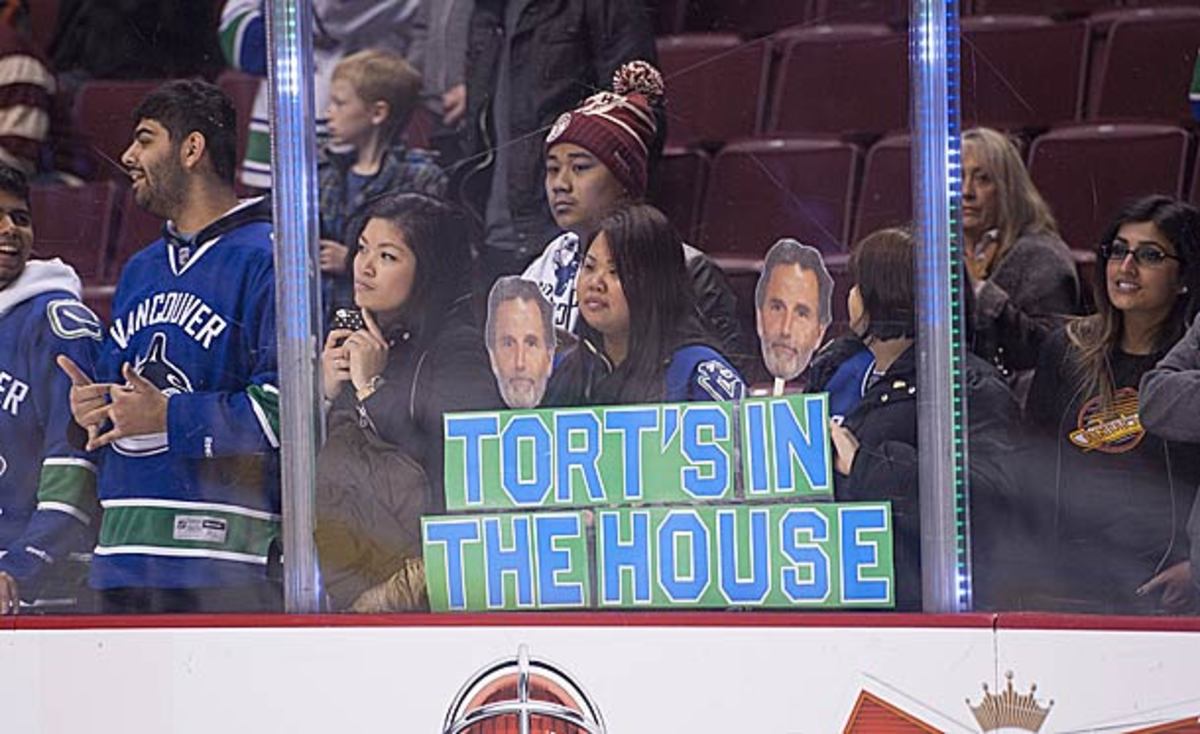 Vancouver Canucks fans hold signs in support of coach John Tortorella