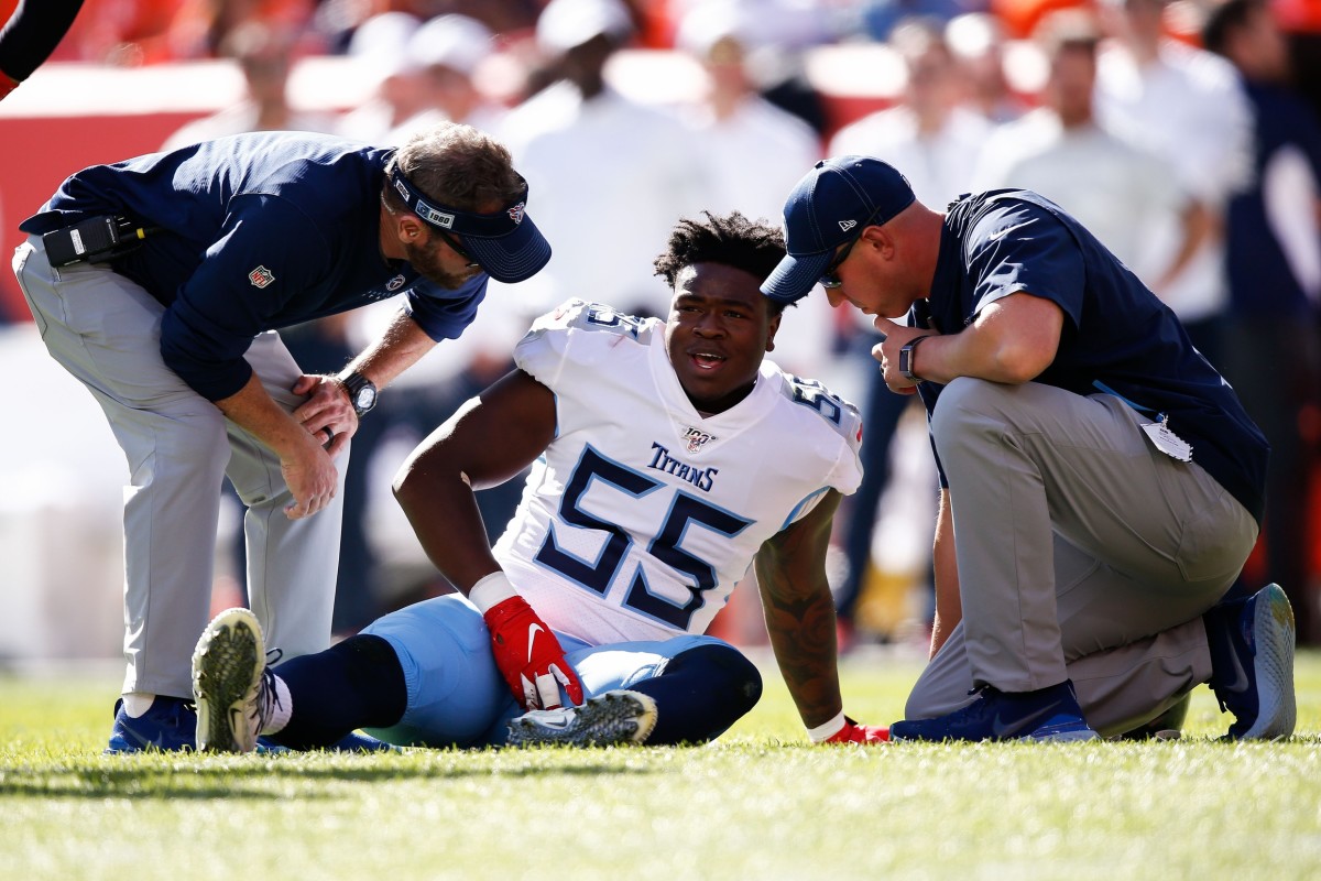 Tennessee Titans linebacker Jayon Brown (55) is tended to after a play in the first quarter against the Denver Broncos at Empower Field at Mile High.