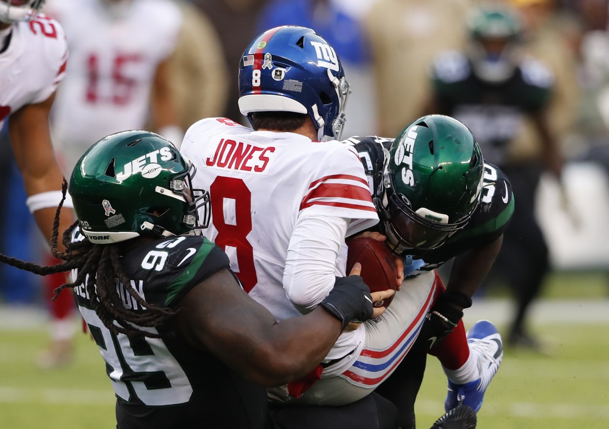 Nov 10, 2019; East Rutherford, NJ, USA; New York Giants quarterback Daniel Jones (8) is sacked by New York Jets nose tackle Steve McLendon (99) and outside linebacker James Burgess (58) during the second half at MetLife Stadium.