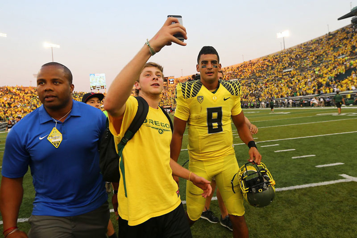 A fan gets a selfie with a potential future NFL star. (Jonathan Ferrey for Sports Illustrated/The MMQB) 