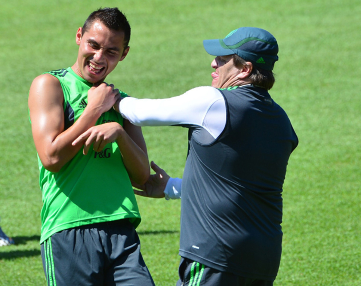 Miguel Herrera, right, jokes with Mexican defender Paul Aguilar during training ahead of Sunday's round of 16 match vs. the Netherlands