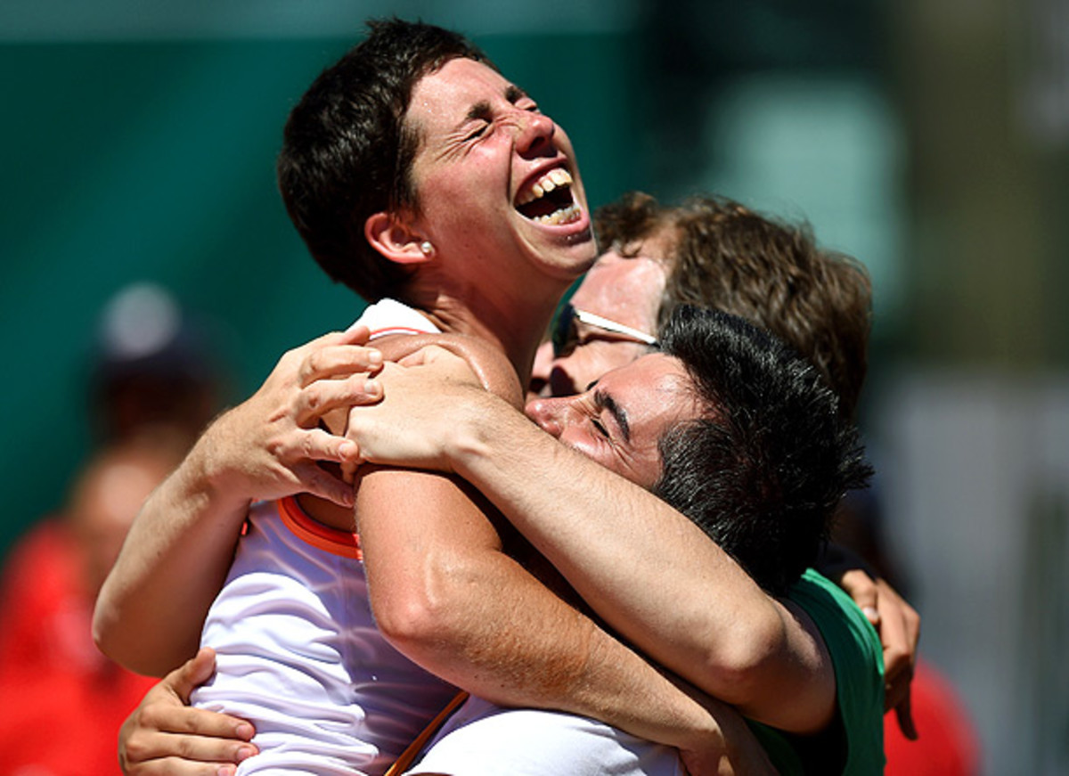Carla Suarez Navarro celebrates winning the Portugal Open title with coaches Javier Budo (center) and Marc Casabo (right). (Francisco Leong/AFP/Getty Images)