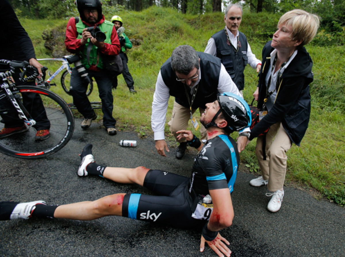 Medics tend to Spain's Xabier Zandio after he crashed during the sixth stage of the Tour de France cycling race over 194 kilometers (120.5 miles) with start in Arras and finish in Reims, France, Thursday, July 10, 2014. Zandio is the second team Sky rider to abandon the race after Britain's Christopher Froome crashed and abandoned yesterday.