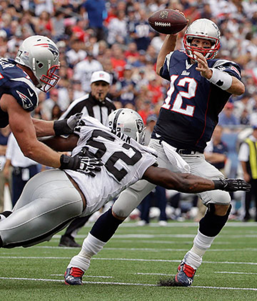 Tom Brady was sacked twice and hit on several more occasions by an active Raiders front. (Steven Senne/AP)