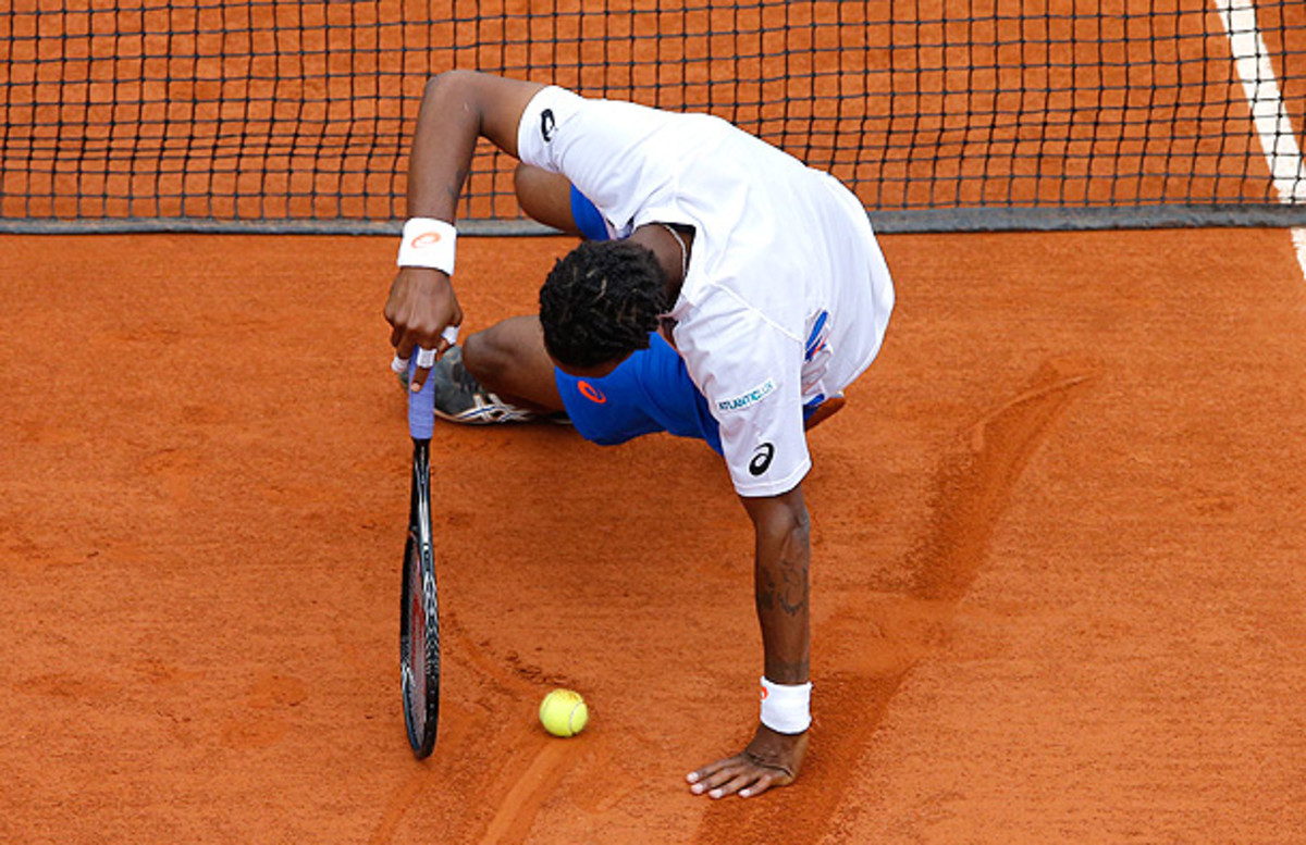 Gael Monfils slips in the clay during his first-round match against Victor Hanescu. (Michel Spingler/AP)