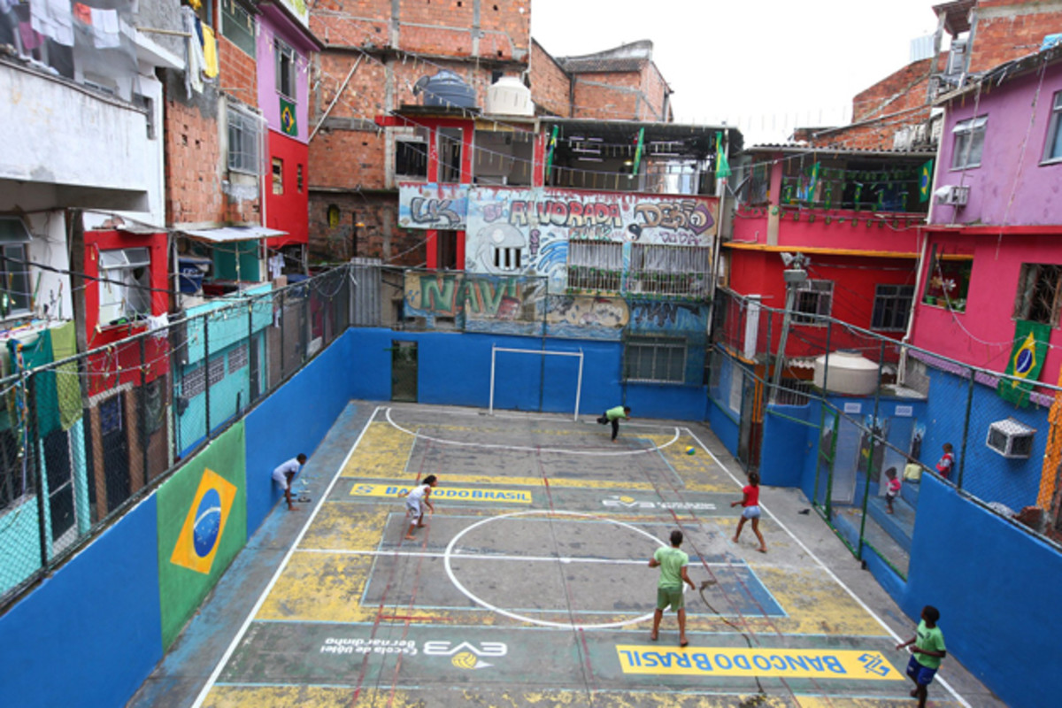 Local children playing soccer on the concrete pitch in the Tavares Basto Favela.
