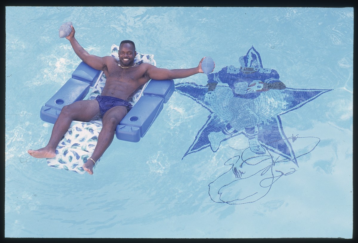 Emmitt Smith of the Dallas Cowboys relaxing on chair in the pool at his home in Dallas, Texas in 1996.
