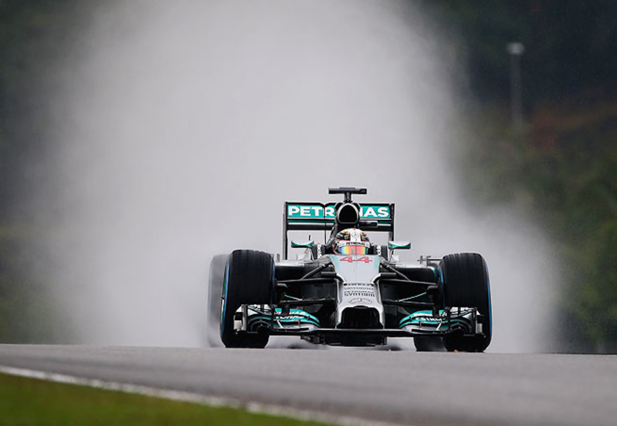 Lewis Hamilton navigated a wet track in Sepang to secure the 33rd pole of his career.