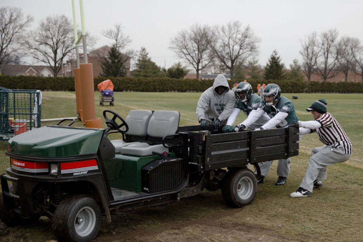 All together: Jason Avant and Zach Ertz pitch in to help free a stuck vehicle during practice in December. (Matt Rourke/AP)