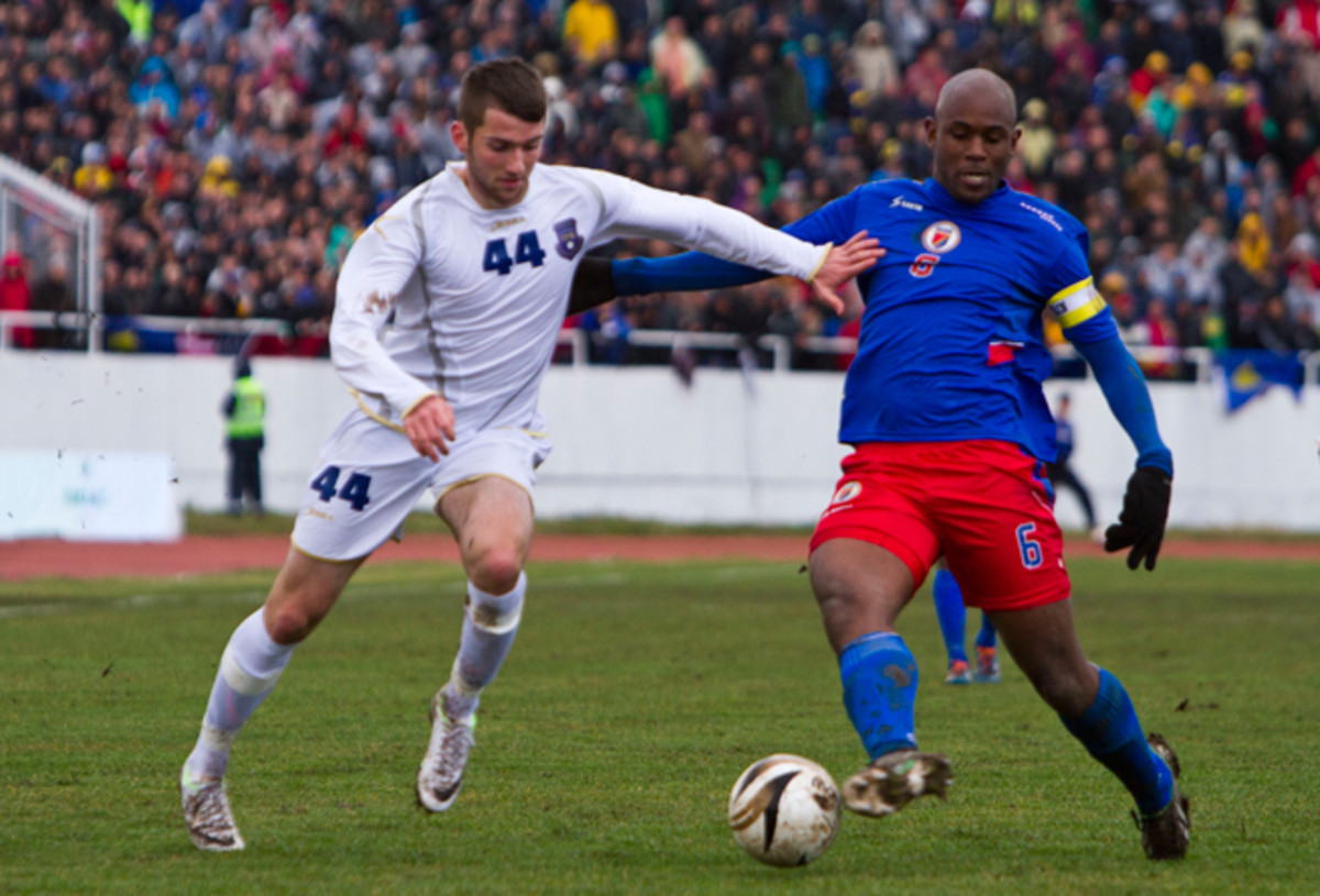 In Kosovo's first international friendly as a member of FIFA, Zymer Bytyqi, left, vies for the ball with Haiti's Frantz Bertin at Adem Jashari Stadium in Mitrovica, Kosovo, on March 5, 2014.