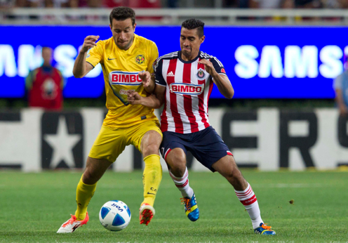 Club America's two-goal scorer Luis Gabriel Rey, left, fights with Chivas' Patricio Araujo for possession in Sunday's rivalry clash.