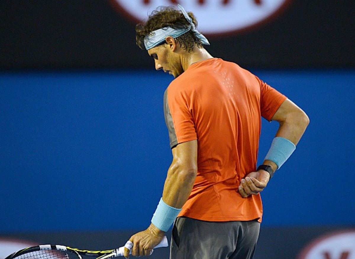 Rafael Nadal grabs his back. (Saeed Khan/AFP/Getty Images)