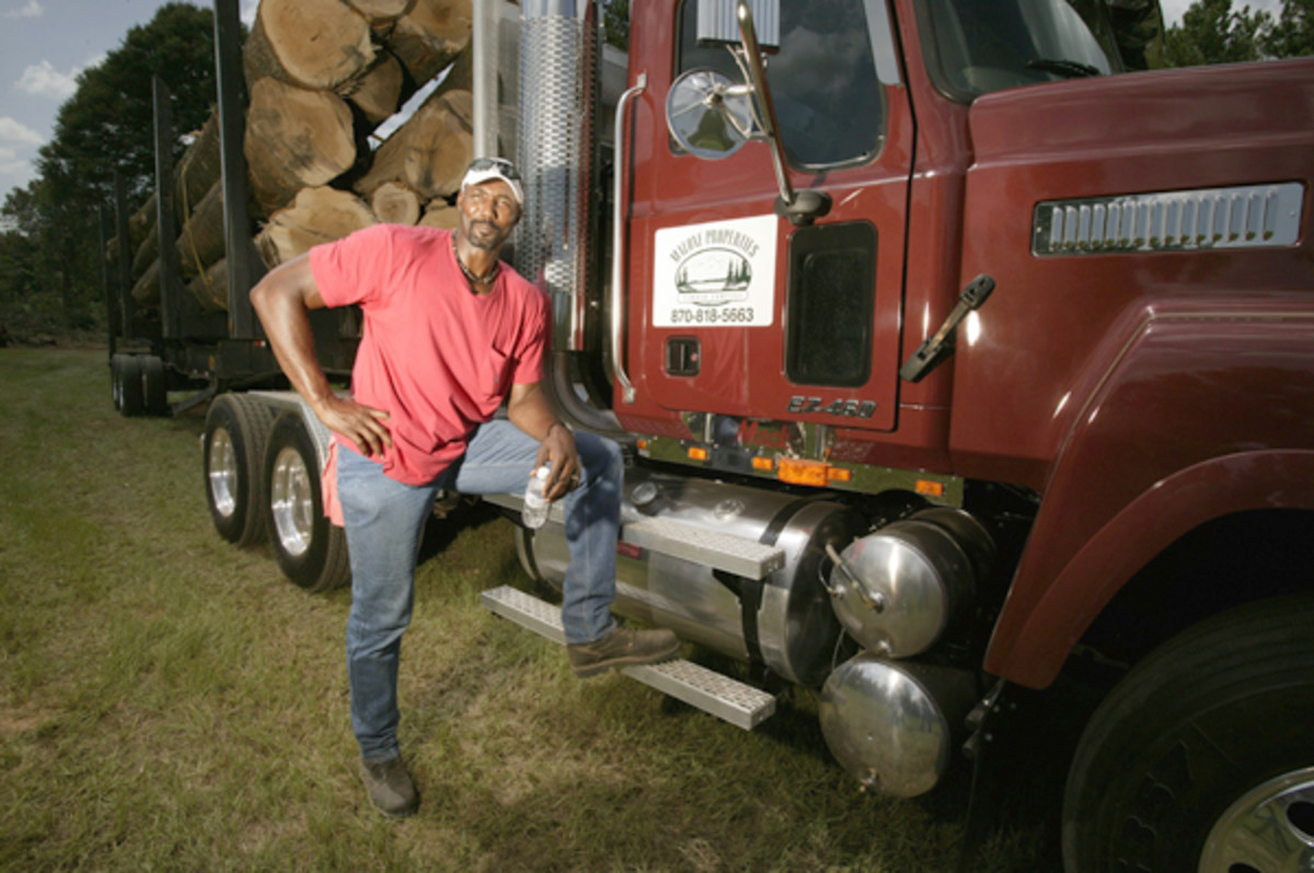 Malone poses outside one of the tractor trailer he drives for his logging company Malone Properties Timber Company in 2003. (Bill Frakes/SI)