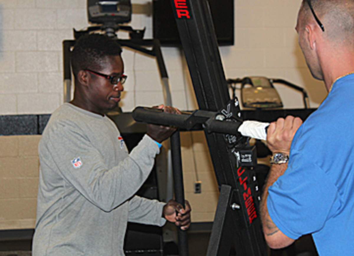 Liburd, setting up the weight room, will work to keep players' nutrition and fitness on track during camp. (Robert Klemko/The MMQB)