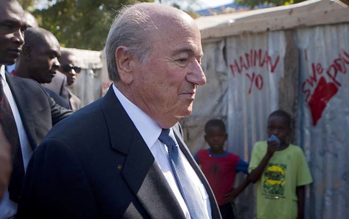 Sepp Blatter walks through a refugee camp in Haiti last week.