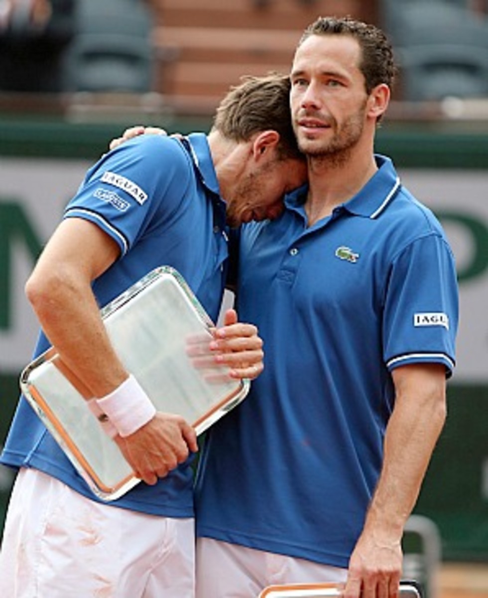 Michael Llodra consoles Nicolas Mahut after losing the men's doubles final (David Vincent/AP)