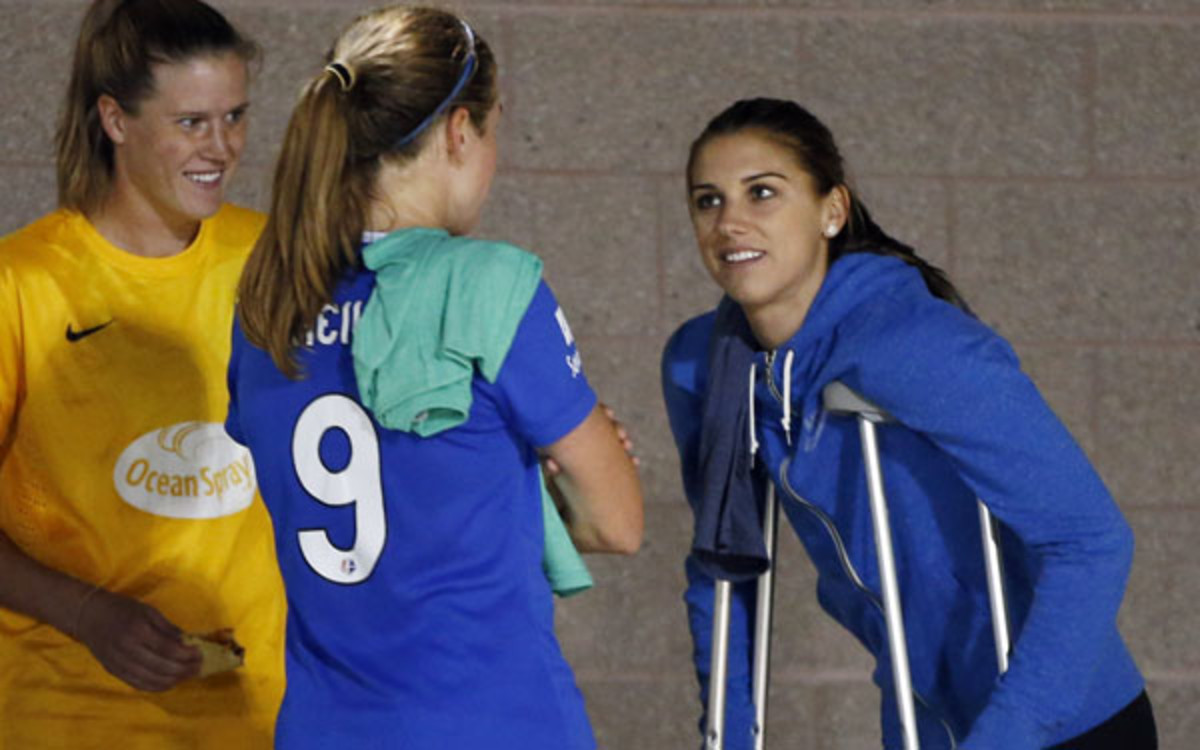 Portland Thorns forward Alex Morgan, right, chats with Boston Breakers goalkeeper Alyssa Naeher, left, and midfielder Heather O'Reilly after injuring  her left leg in a game. (AP Photo/Elise Amendola