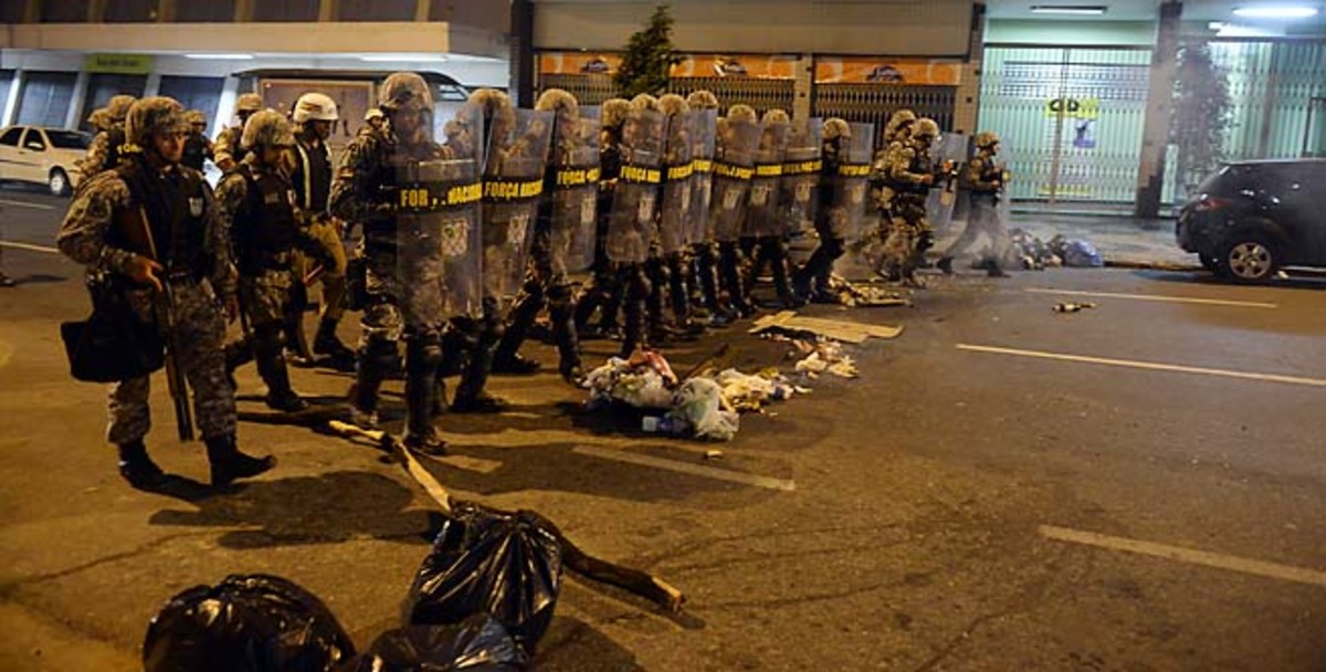 Policemen move into position in the street during Saturday's protests in Belo Horizonte.