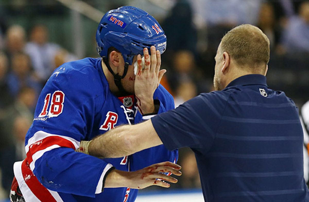 Marc Staal leaves the ice after being hit in the face by a slap shot.