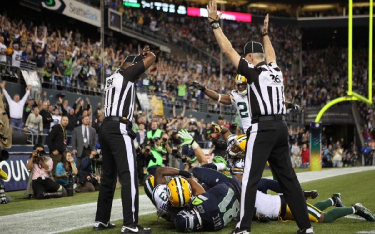 The ref with his hands up will also be umpiring a softball game put on by Seahawks corner Richard Sherman. (Otto Greule Jr/Getty Images)