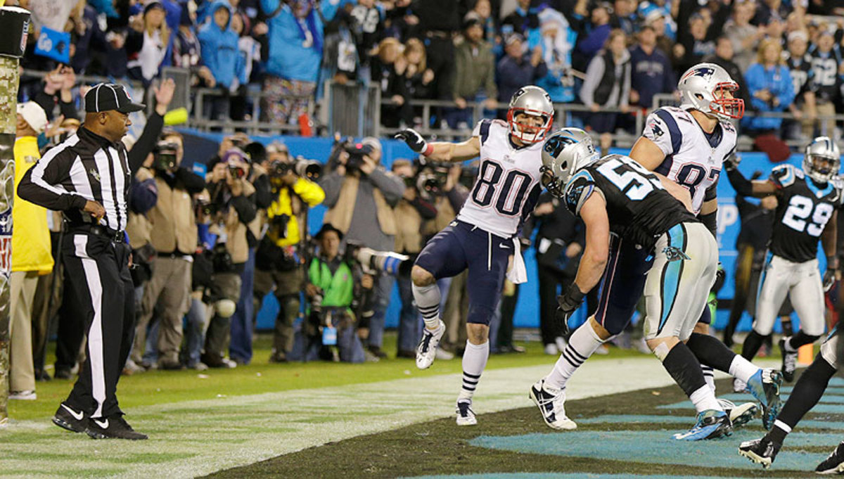 Back judge Terrence Miles goes for his flag after seeing Luke Kuechly (59) collide with Rob Gronkowski (87) in the end zone on the game's final play, but no penalty was called. (Chuck Burton/AP)