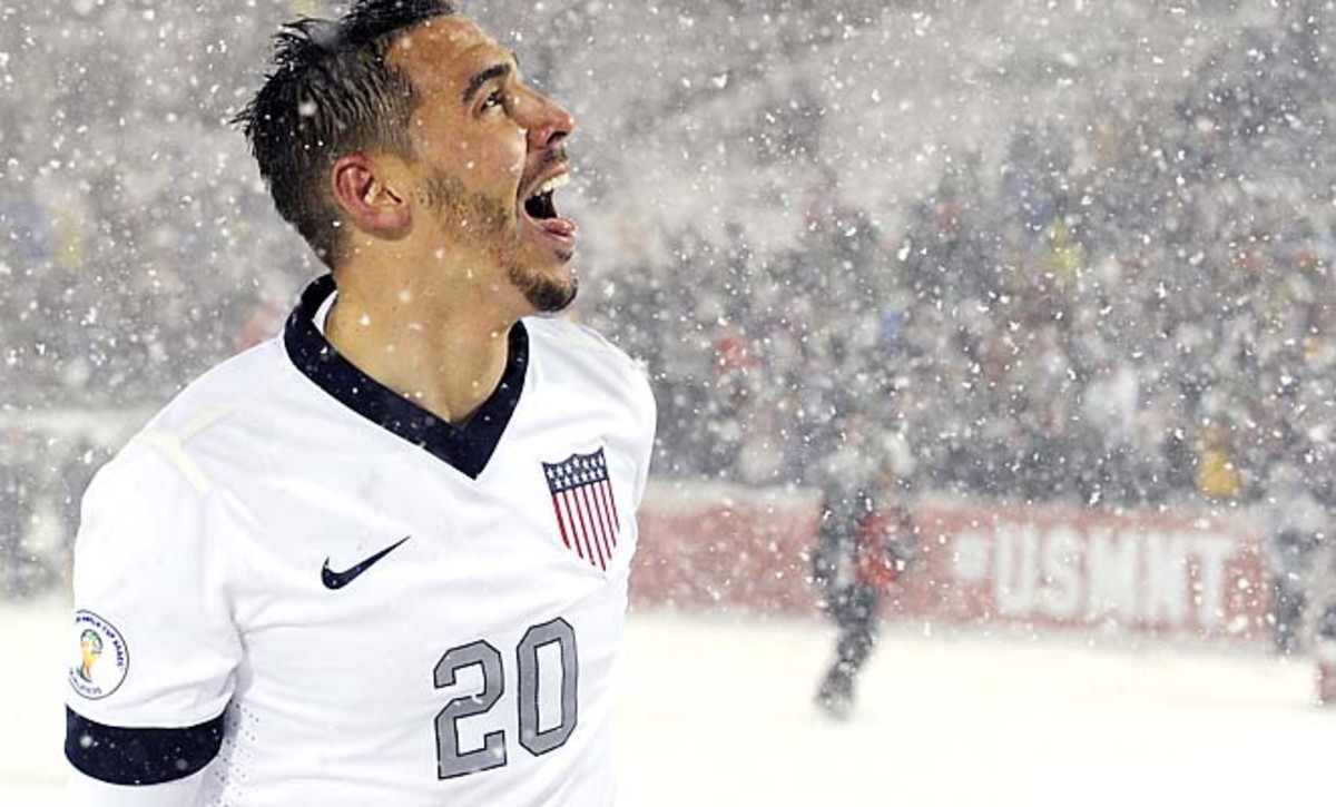 U.S. defender Geoff Cameron tries to catch snow flakes on his tongue after the victory.