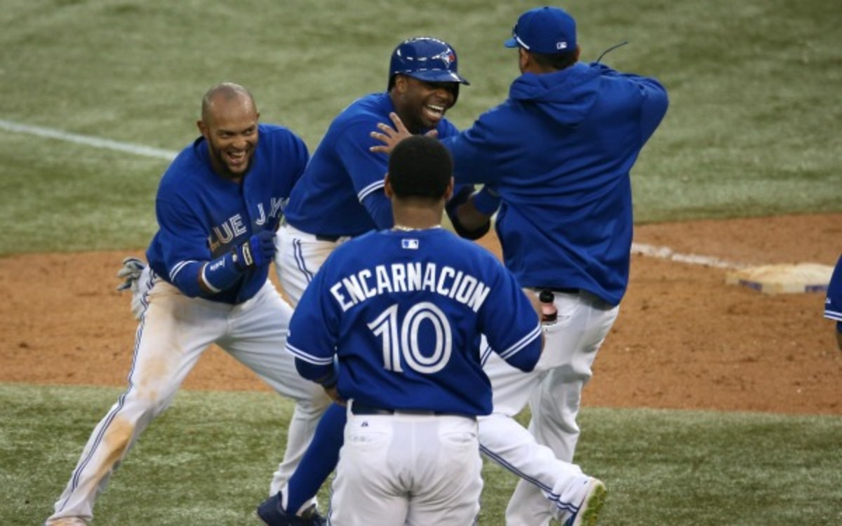 Blue Jays teammates congratulate Rajai Davis after driving in the winning run in the 18th inning. (Tom Szczerbowski/Getty Images)
