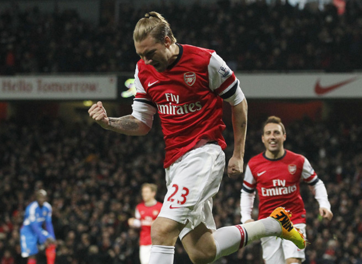 Nicklas Bendtner celebrates his opening goal as Arsenal defeated Hull City 2-0 on Wednesday to retain its four-point lead atop the Premier League.