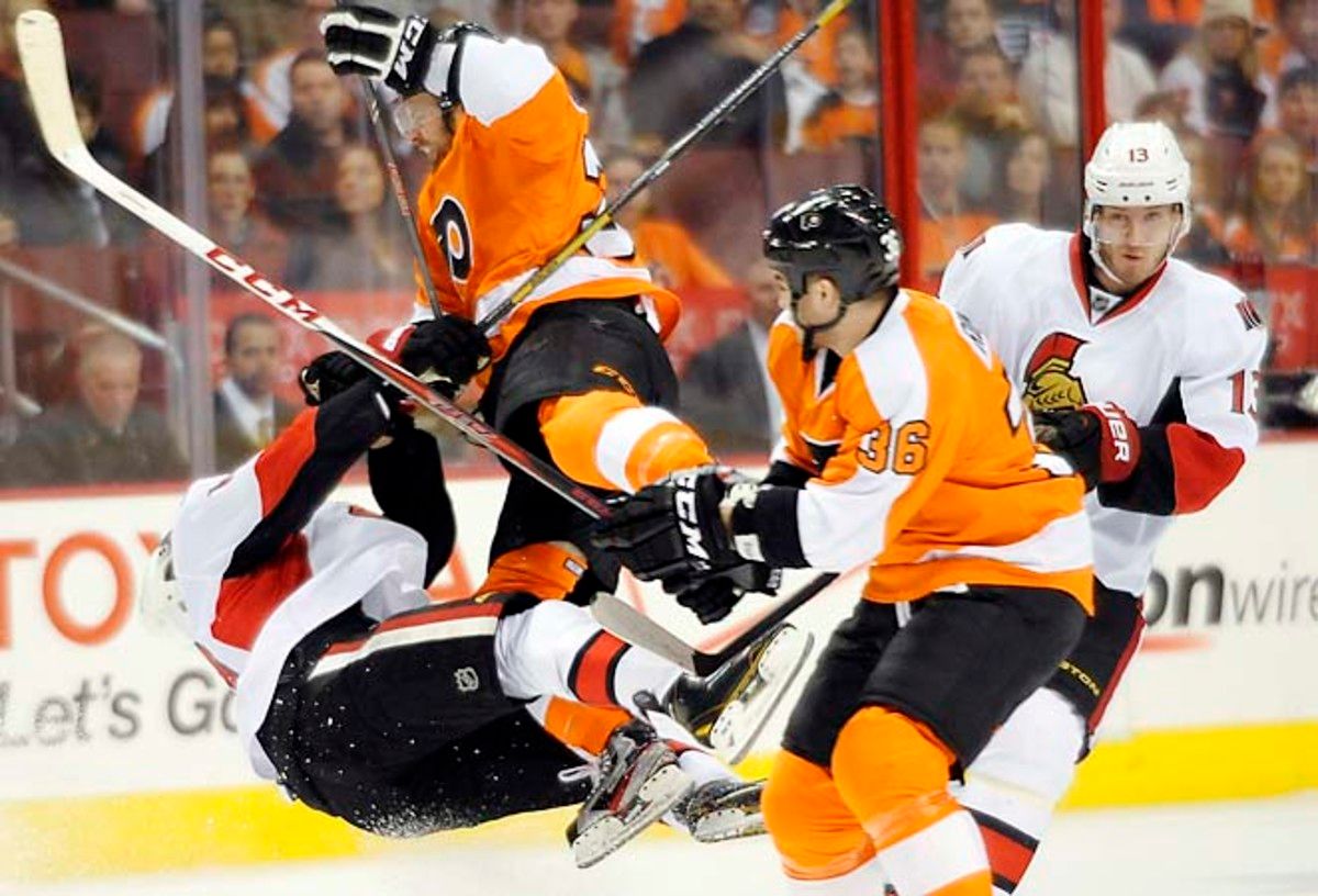 The Flyers' Harry Zolnierczyk (left) hits the Senators' Mike Lundin in Saturday's game.