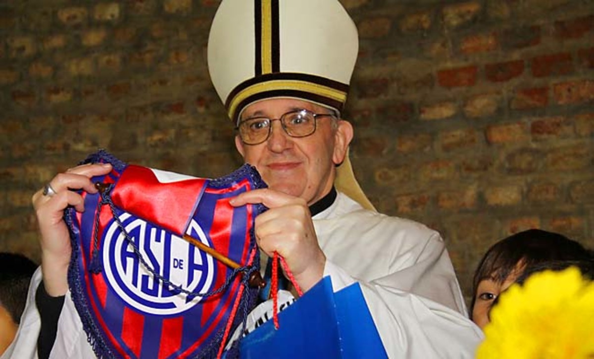 Pope Francis, then Argentine Cardinal Jorge Bergoglio, poses with an emblem from the San Lorenzo soccer club.