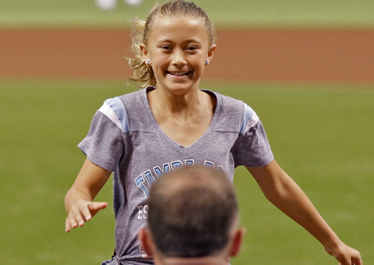 Alayna Adams, 9, is reunited with her father, Lt. Col. Will Adams, disguised as a Tampa Bay Rays catcher for the ceremonial first pitch.  (AP)