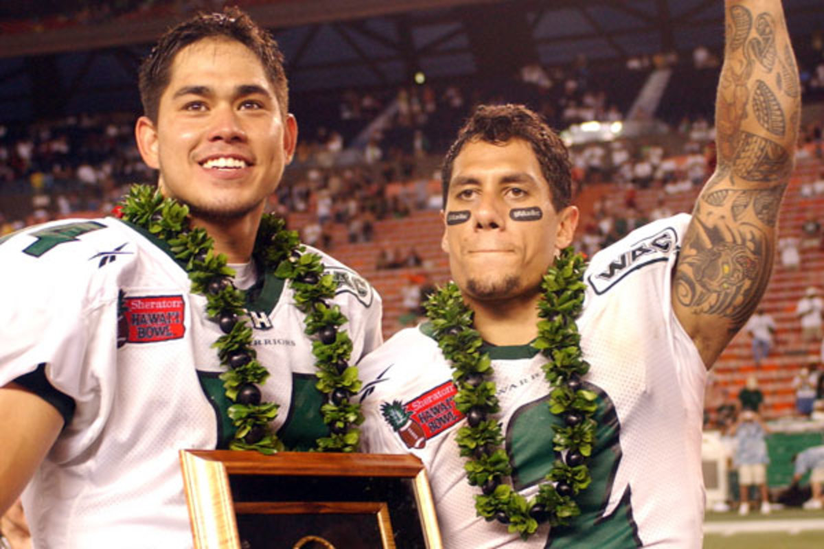 Chad Owens (right) celebrates with Hawaii teammate Timmy Chang after winning the 2004 Hawaii Bowl. (AP)
