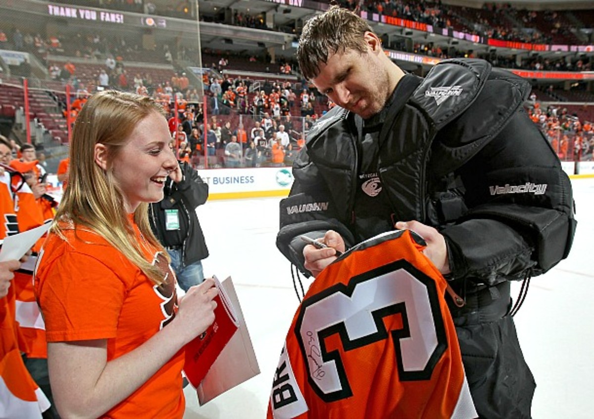 Former Philadelphia Flyers goalie Ilya Bryzgalov signs an autograph for a fan.