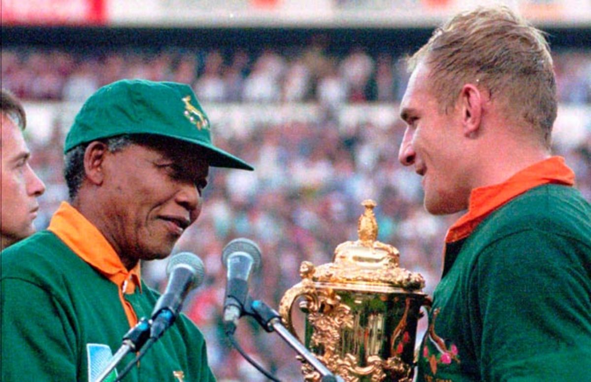 Nelson Mandela hands the 1995 Rugby World Cup trophy to South African captain Francios Pienaar.