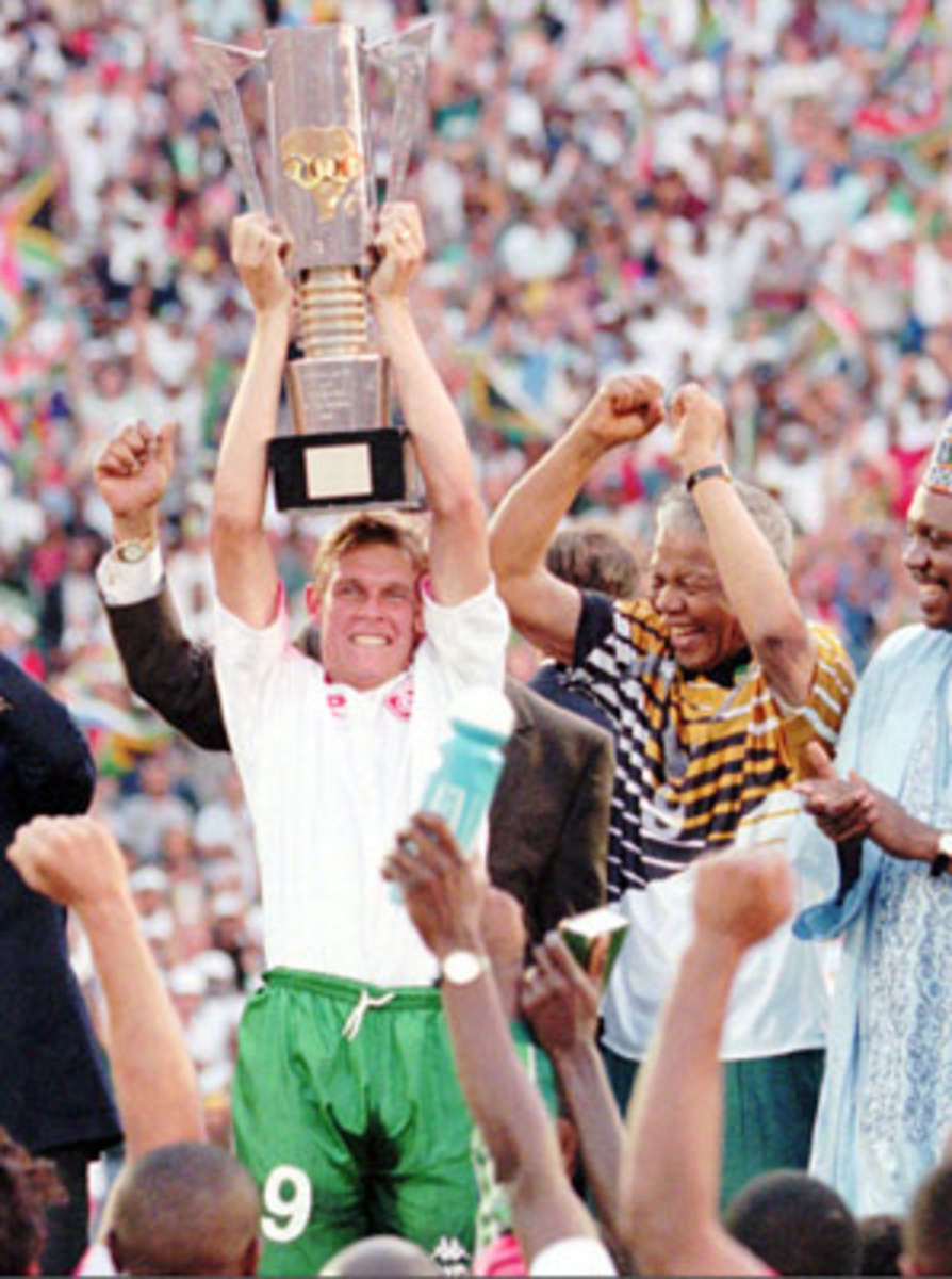 Mandela celebrates after handing the 1996 African Cup of Nations trophy to South African captain Neil Tovey.