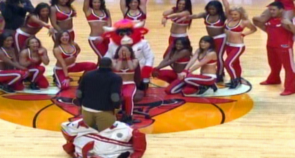 A man pops out of a mascot's costume to propose to his girlfriend, a Bulls dancer. (TNT)