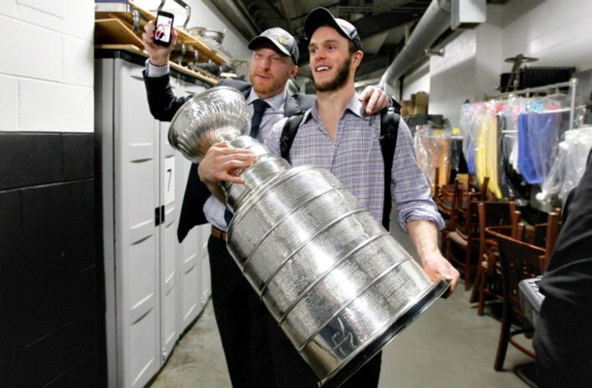 Jonathan Toews carries the Stanley Cup.