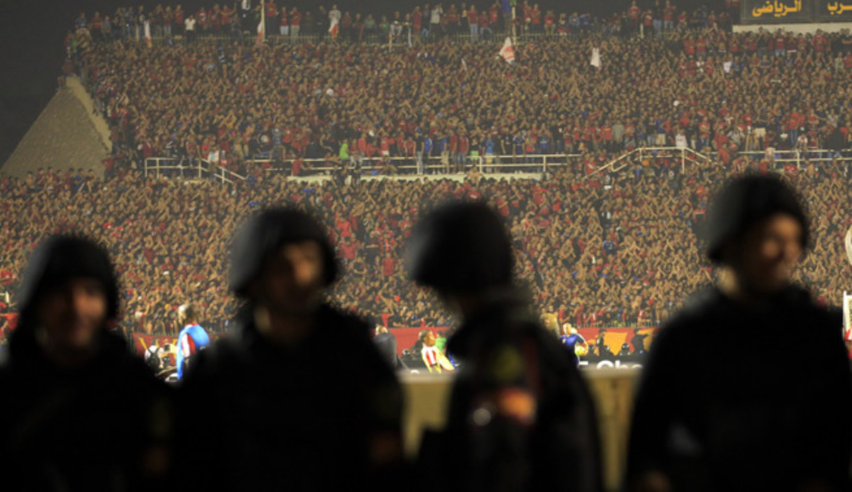 Riot police stand on guard as Egypt's Al Ahly fans cheer during their African Champions League final soccer match against South Africa's Orlando Pirates at the Arab Contractors Stadium in Cairo.