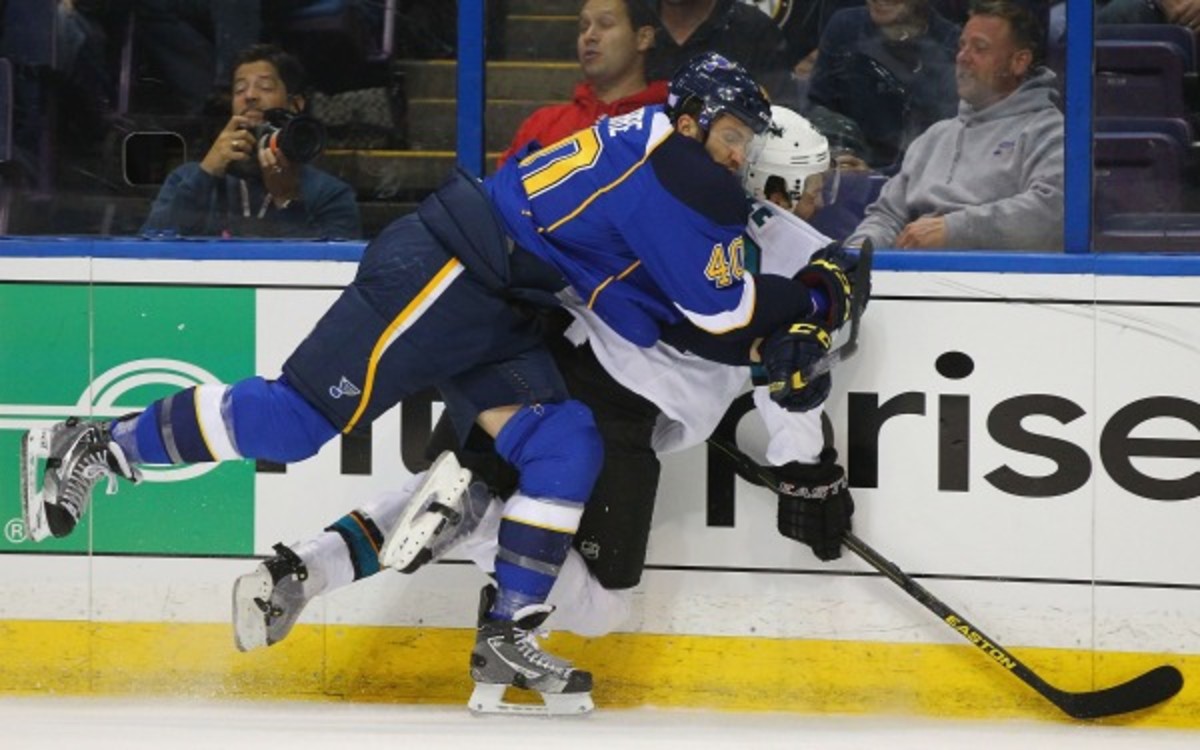 Dan Boyle is ran into the boards by Blues center Maxim Lapierre (Dilip Vishwanat/Getty Images)