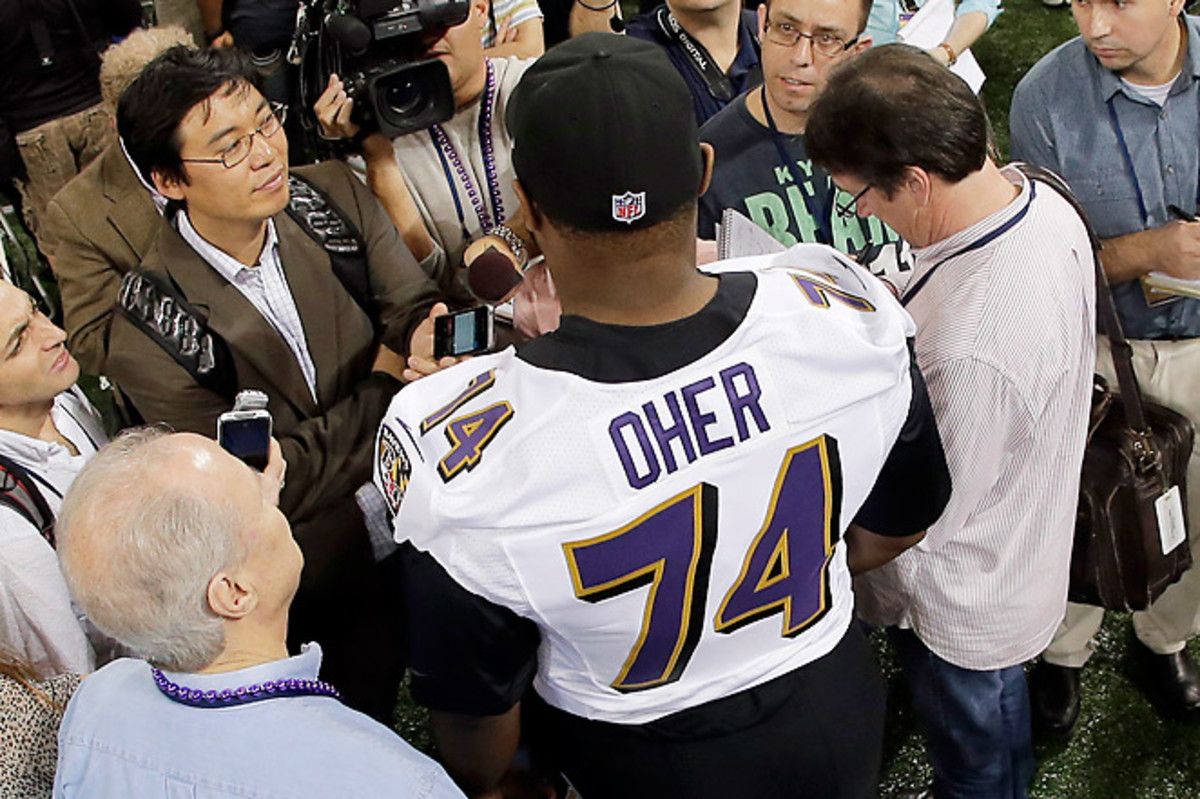 Michael Oher talks to a throng of reporters, including SI's Don Banks (immediate right).