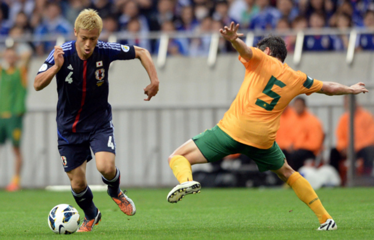 Japanese midfielder Keisuke Honda dribbles past Australia's Mark Milligan. The teams drew 1-1, and Japan became the first team to qualify for the World Cup. (Toshifumi Kitamura/AFP/Getty Images)