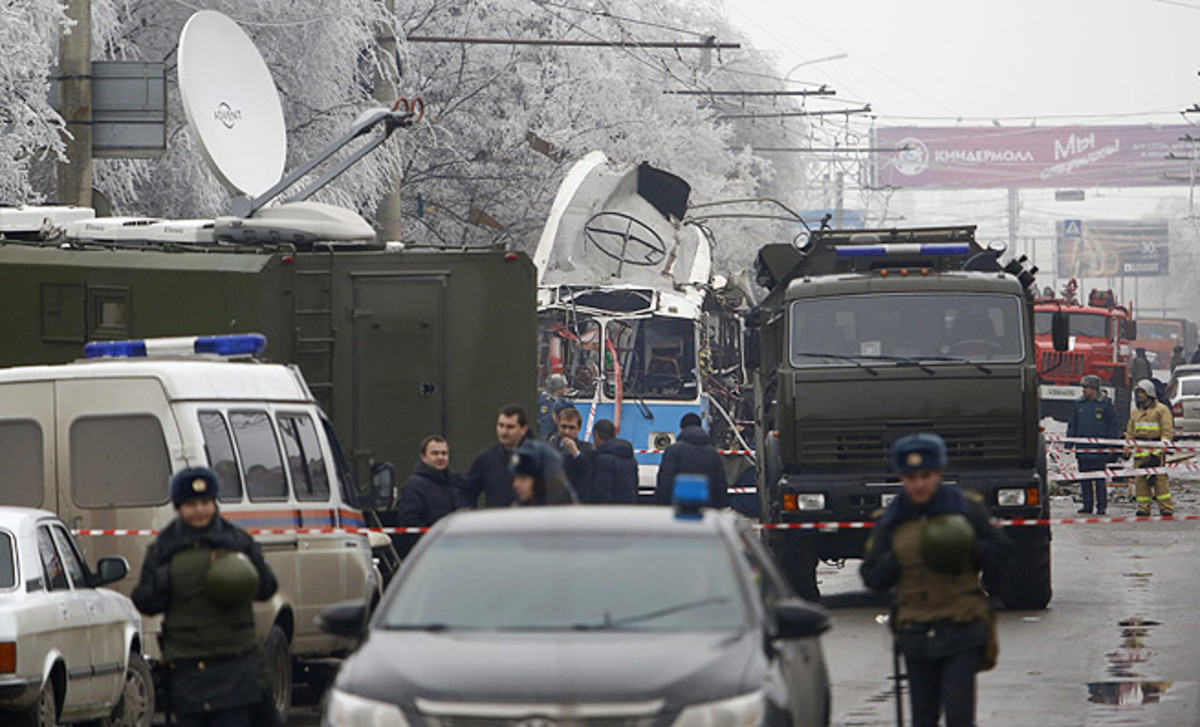 Security vehicles surround a trolleybus after a suicide bombing killed at least 10.