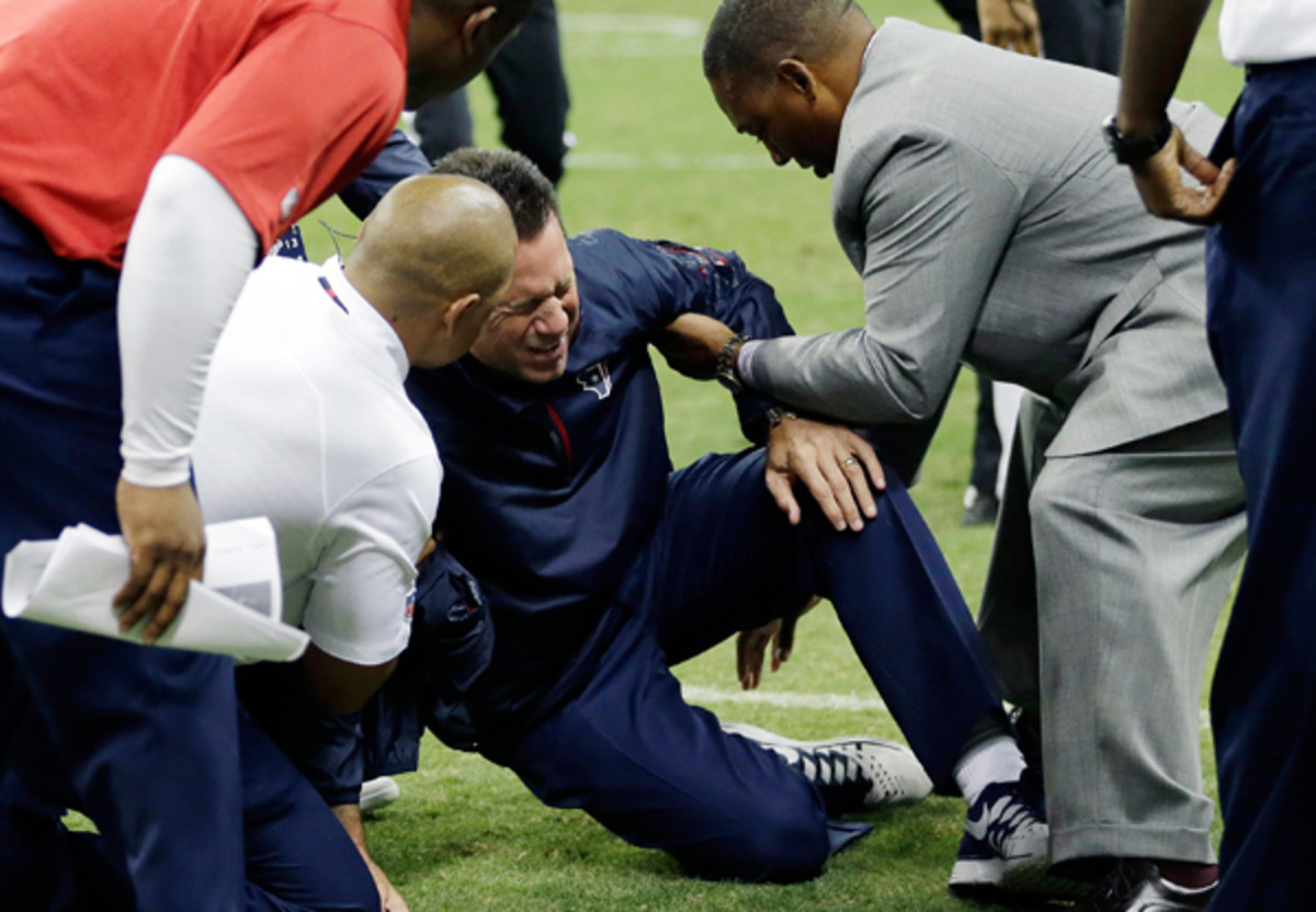 Gary Kubiak was attended to immediately after collapsing on the field Sunday evening. (David J. Phillip/AP)