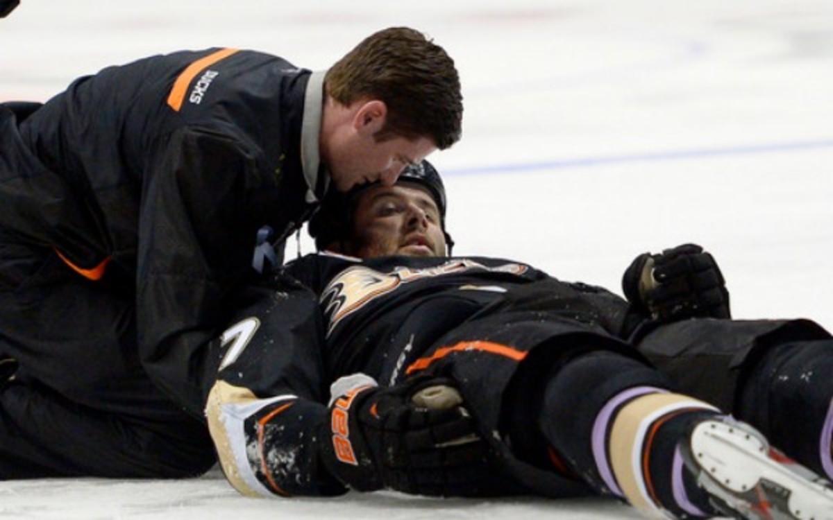 Ducks forward Dustin Penner is seen by a trainer after being injured. (AP Photo/Mark J. Terrill)