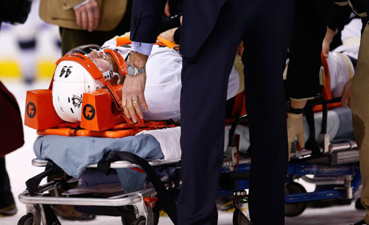 Brooks Orpik was taken off the ice on a stretcher after an altercation in the first period of Saturday's game in Boston.