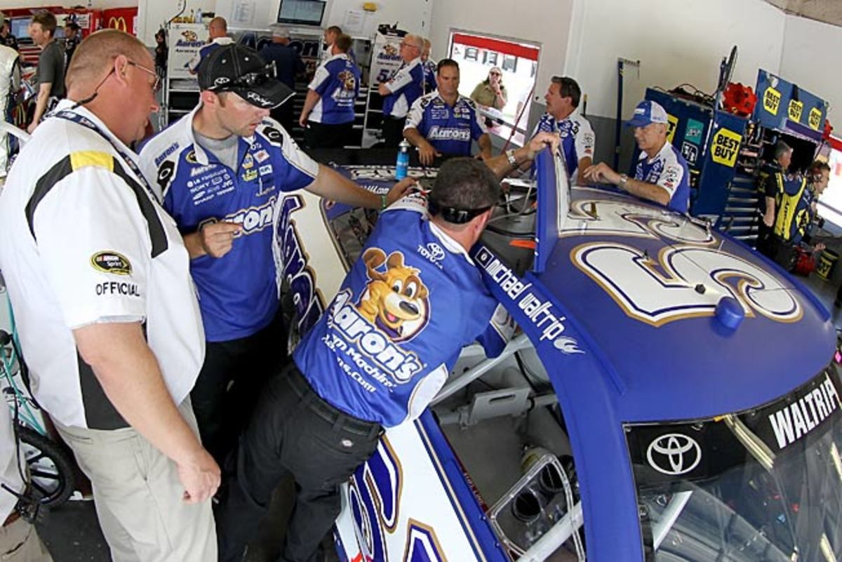 Crew members work on the roof flaps of Michael Waltrip's Toyota during practice at Daytona on July 4.